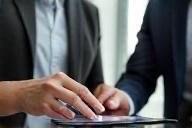 Two people discussing a plan on a tablet